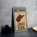 A vintage-style metal sign with the text "WEST VIRGINIA 1863 USA" and a map of the state of West Virginia.