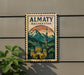 a sign with a mountain landscape and a building, mounted on a wall.