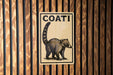 a sign with the word "COATI" written on it, which is mounted on a wooden wall.