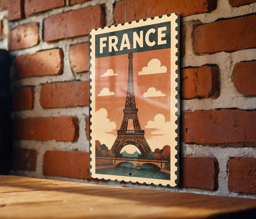 A framed poster of the Eiffel Tower is displayed on a brick wall, with the word "FRANCE" written on it.
