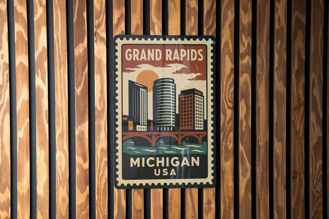 A vintage-style postage stamp depicting the Grand Rapids, Michigan, USA, with a cityscape and a bridge.