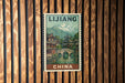 A vintage postage stamp from China depicting a traditional Chinese village with a bridge and mountains in the background.