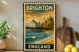 A vintage-style poster of Brighton, England, featuring a coastal scene with a pier and buildings, is displayed on a wall next to a wooden cutting board and some potted plants.