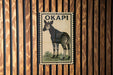 A wooden wall with a framed poster of a zebra, which is the main focus of the image.