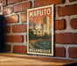 A vintage-style map of Maputo, Mozambique, displayed on a brick wall.