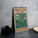 A vintage-style metal sign with the text "SHELTLAND ISLANDS SCOTLAND" and an illustration of a map of Scotland, along with a small boat, is displayed on a gray countertop.