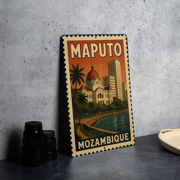 A vintage-style metal sign with the text "MAPUTO MOZABIQUE" and an illustration of a cityscape with a dome-shaped building, palm trees, and a body of water.