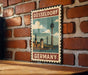 A vintage-style poster of Düsseldorf, Germany, featuring the city's iconic landmarks and skyline, is displayed on a brick wall.