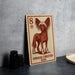 A Chinese Crested Dog illustration on a wooden postcard or sign, placed on a table next to some black camera lenses.