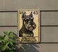 A miniature schnauzer dog stamp is displayed on a wall, with a plant to the left.