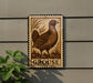 a postage stamp-like sign with a bird illustration, mounted on a wall next to a plant.