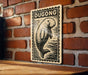 A wooden table with a decorative sign featuring a drawing of a dugout or dugout-like structure, mounted on a brick wall.