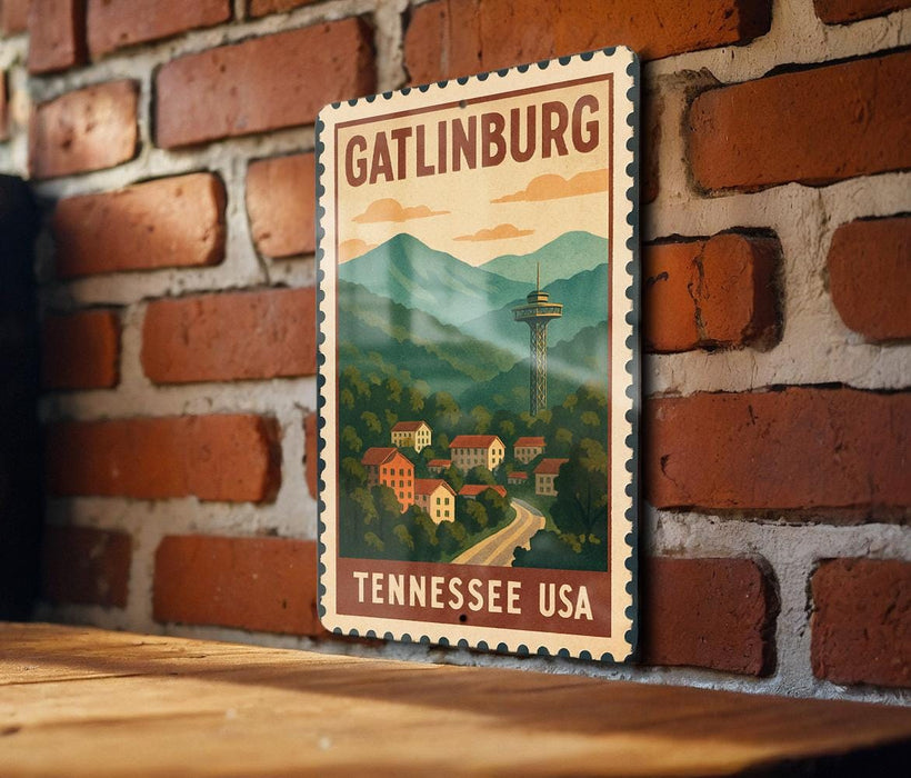 A vintage postage stamp depicting the GATLINBURG, Tennessee USA, with a mountain landscape and a tower in the background.