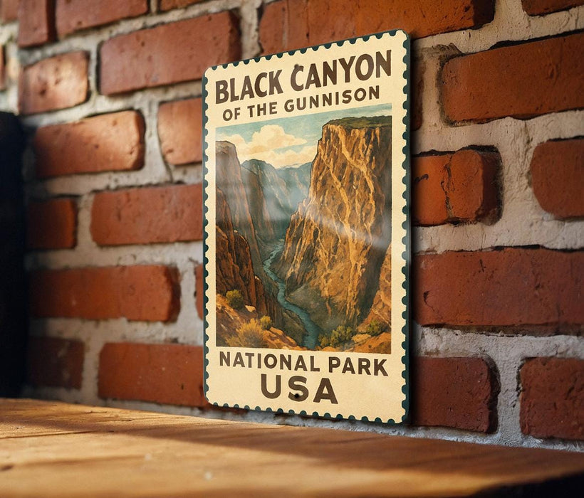 A vintage-style metal sign displaying the name "Black Canyon of the Gunnison" and the location "National Park USA" is mounted on a brick wall.