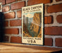 A vintage-style metal sign displaying the name "Black Canyon of the Gunnison" and the location "National Park USA" is mounted on a brick wall.