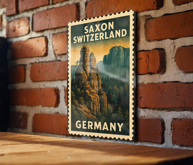 A vintage postage stamp featuring Saxon Switzerland, with a mountain landscape and the text "SAXON SWITZERLAND GERMANY" displayed on a brick wall.