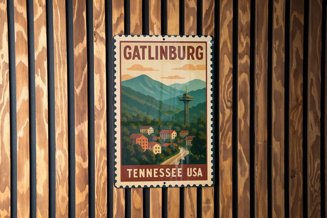 A vintage-style metal sign with the text "GATLINBURG TENNESSEE USA" displayed on a wooden wall.