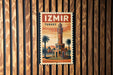 A vintage-style poster of the Izmir Tower, a famous landmark in Turkey, is displayed on a wooden wall.