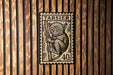 A wooden wall with a framed stamp featuring a monkey.