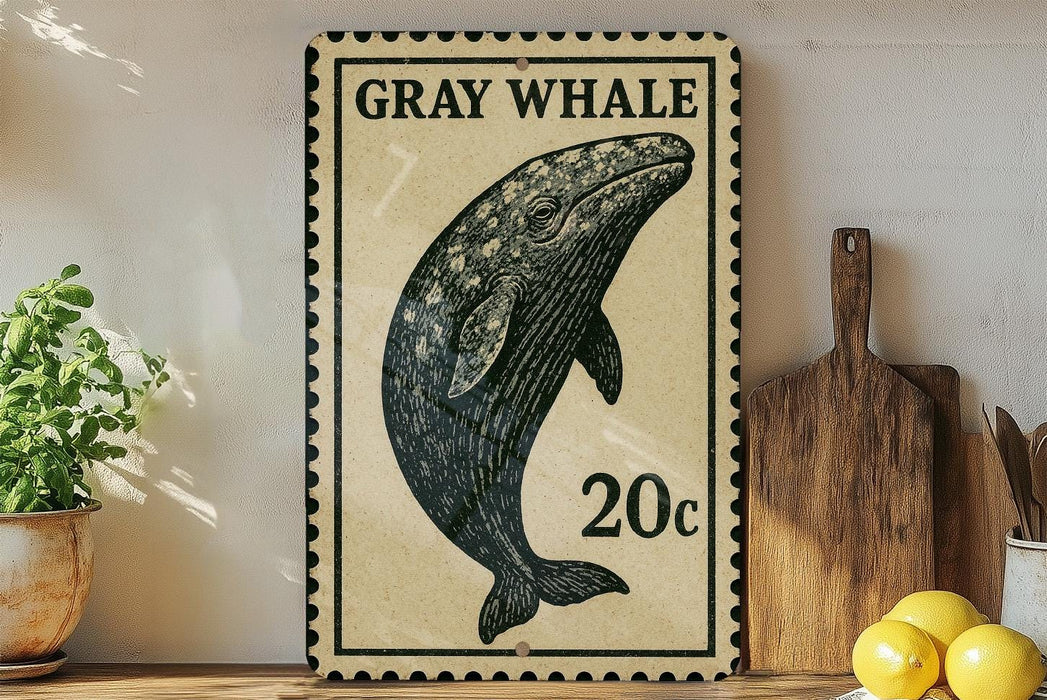 a framed illustration of a gray whale, a 20-cent stamp, and some kitchen utensils on a wooden surface.