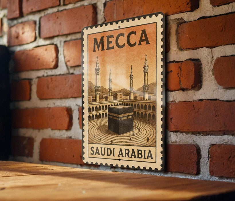 A vintage-style metal sign with the text "MCCA SAUDI ARABIA" and an illustration of the Kaaba, the most sacred site in Islam, is displayed on a brick wall.