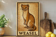 a sign with a drawing of a weasel, placed on a shelf next to a wooden cutting board and some lemons.