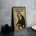 a framed illustration of a capuchin monkey on a wall, with a stack of black camera lenses and a white plate visible in the foreground.