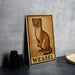 A wooden sign featuring an illustration of a weasel, with the word "WEASEL" written below it.