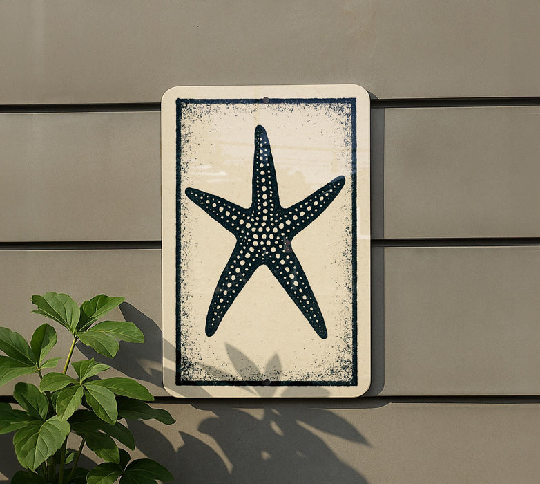 a white sign with a black starfish design on it, mounted on a wall.