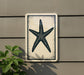 a white sign with a black starfish design on it, mounted on a wall.