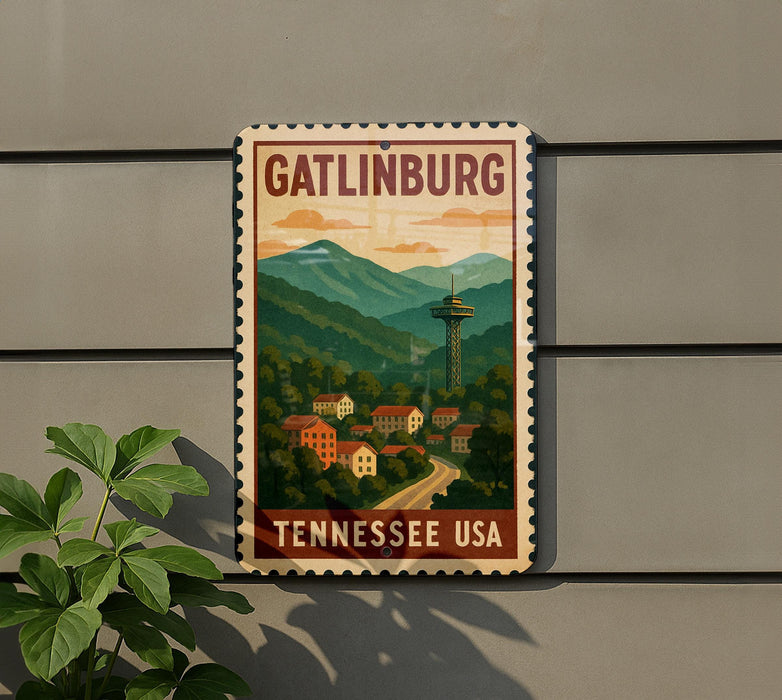 A vintage-style sign for Gatlinburg, Tennessee, featuring a mountain landscape with a tower in the background.
