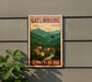 A vintage-style sign for Gatlinburg, Tennessee, featuring a mountain landscape with a tower in the background.