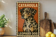 A metal sign with a leopard dog illustration, placed on a wooden surface next to a wooden cutting board and some lemons.