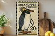 A vintage-style stamp depicting a rockhopper penguin, with the text "ROCKHOpper PENGUIN" and the price "20c" printed on it. The stamp is displayed on a wooden shelf, with a potted plant, a wooden cutting board, and some lemons nearby.