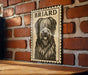 A framed image of a shaggy dog with a black and white illustration on a brick wall.