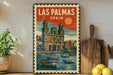 A vintage-style metal sign with a colorful illustration of a cityscape and boats, featuring the text "LAS PALMAS SPAIN" prominently displayed.