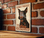 a German Pinscher dog, which is a breed of dog known for its distinctive appearance and characteristics. The dog is depicted in a stamp-like format, with the text "German Pinscher" and "Deutschland" printed on it, indicating that it is a German pinscher dog from Germany.