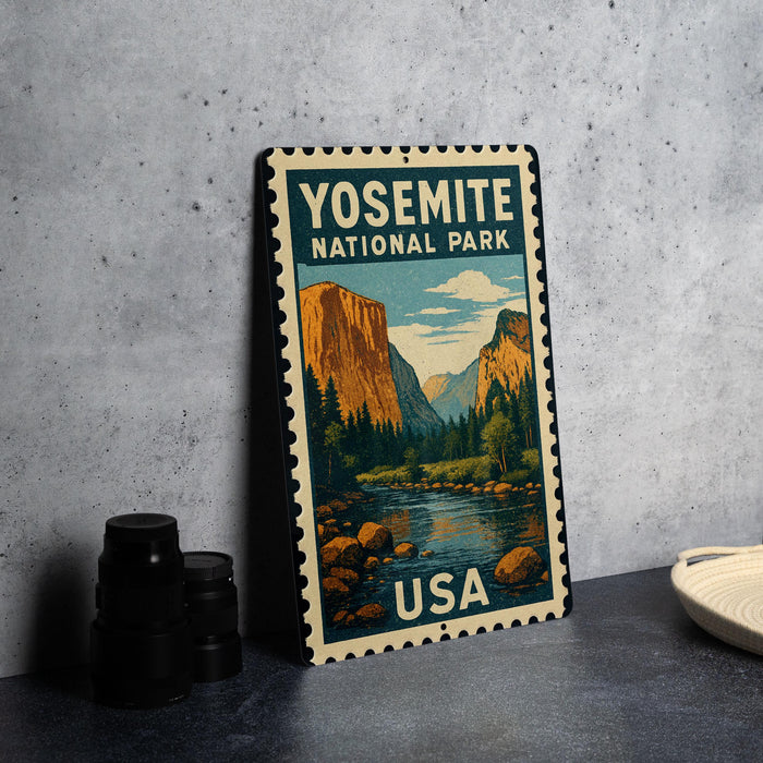 A vintage-style metal sign with the text "YOSEMITE NATIONAL PARK USA" printed on it, depicting a scenic landscape with mountains and a river.