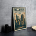 A metal sign with the text "RALEIGH NORTH CAROLINA USA" and an illustration of the city skyline of Raleigh, North Carolina, USA.