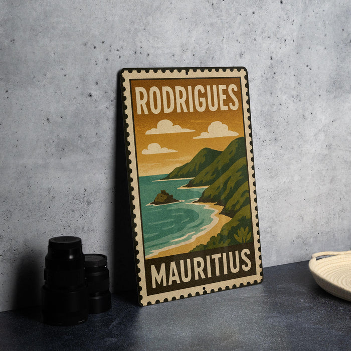 A vintage-style metal sign with the text "RODRIGUEZ MAURITIUS" and an illustration of a coastal landscape with mountains, water, and clouds.