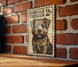 a wooden table with a framed poster of a dog, specifically a Norfolk Terrier, hanging on a brick wall.