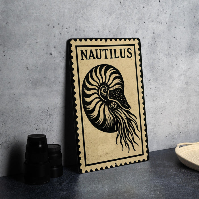 a metal plate with a nautilus shell design, placed on a table next to some black camera lenses.
