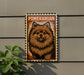A metal sign with a pomeranian dog illustration on it, mounted on a wall.