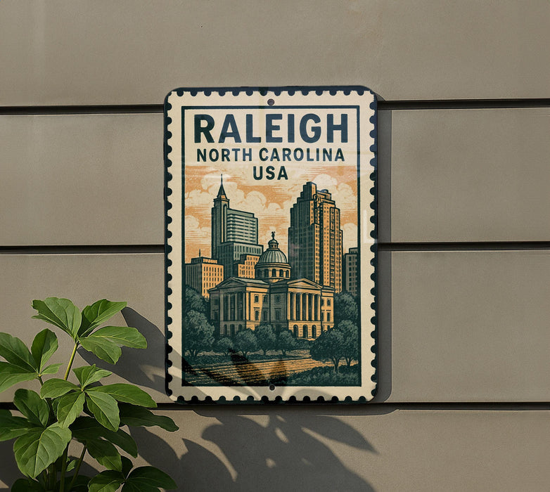 A metal sign with the text "RALEIGH NORTH CAROLINA USA" and an illustration of a city skyline, mounted on a wall.