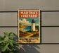 A vintage-style metal sign with a lighthouse and coastal landscape, mounted on a wall.