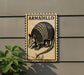 a sign with the word "ARMADillo" on it, mounted on a wall next to a plant.