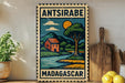 A vintage-style metal sign with a colorful illustration of a rural landscape, including a house, trees, and a river, is displayed on a shelf next to a wooden cutting board and some potted plants.