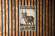 a wooden wall with a framed illustration of a gazelle, which is a type of antelope.