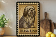 a framed illustration of a dog, specifically a Lhasa Apso, sitting on a wooden surface.