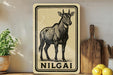a decorative sign with a black and white illustration of a goat, placed on a wooden surface next to a wooden cutting board and some lemons.